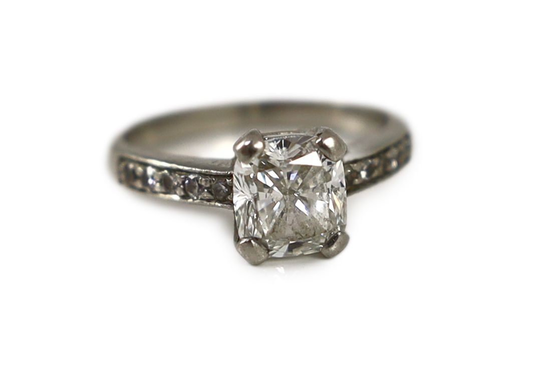 A modern platinum and single stone brilliant cushion cut diamond, with diamond set shoulders